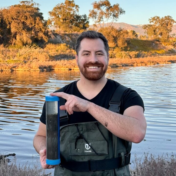 George Schaible holding a sediment core at the UCSB lagoon